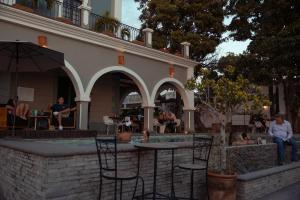 Eine Gruppe von Menschen sitzt an einem Tisch am Pool in der Unterkunft Hotel Villa 1927 in Chapala