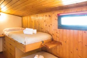 a room with a bed in a wooden cabin at Pian delle Betulle Alpine Loft in Margno
