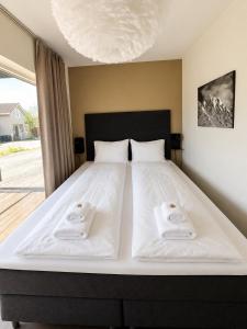 a bedroom with a large bed with two towels on it at Nordic Comfort Suite with Hot Tub in Storeidet