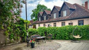 a patio with a table and chairs in front of a house at Kuldiga Kalna Apartment in Kuldīga