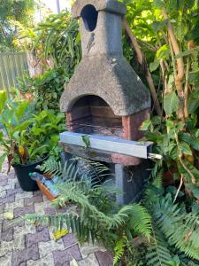 an outdoor brick oven in a garden with plants at pti caze Hoarau in Le Tampon
