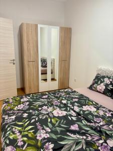 a bedroom with a bed with a floral comforter at Kapije Uba 51 in Ub +3 photos