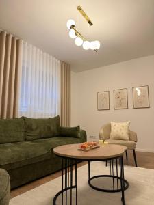 a living room with a green couch and a table at A&L Luxury Apartment in Tuzla