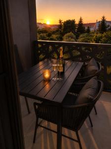 a wooden table with two glasses and a bottle of wine at Sunset Aura in Sukošan +3 photos
