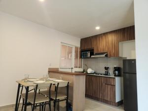 eine Küche mit Tisch, Stühlen und Kühlschrank in der Unterkunft Depa Piky in La Cañada