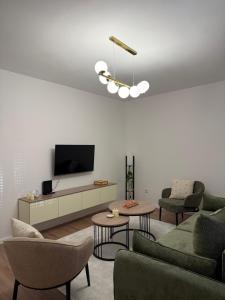 a living room with two couches and a tv at A&L Luxury Apartment in Tuzla