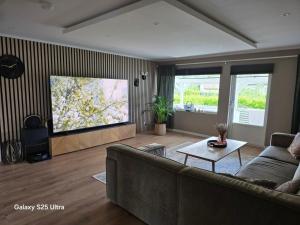 a living room with a couch and a flat screen tv at Kristiansand Mosby1 in Kristiansand