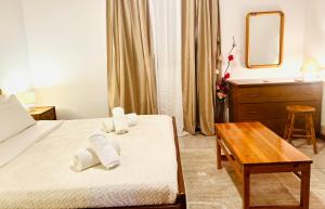 a bedroom with a bed and a table and a mirror at Gradakia Cottages 2 in Argostoli