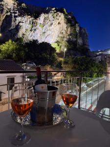 two glasses of wine on a table with a view at Vanity Suite in Cefalù