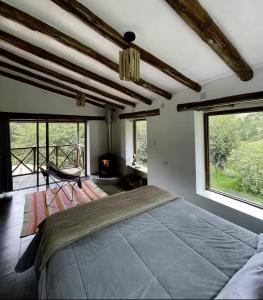 a bedroom with a large bed and large windows at Aldealma in Pisac