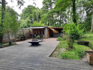 a backyard with a cabin with a wooden deck at Chalet dans la nature avec spa in Espins