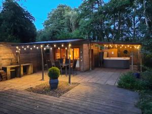a house with a patio with lights on it at Chalet dans la nature avec spa in Espins