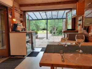 a kitchen with a table with wine glasses on it at Chalet dans la nature avec spa in Espins