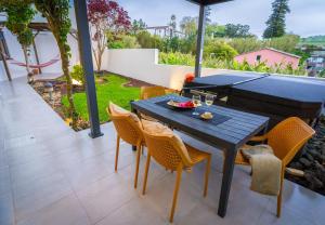 a patio with a table and chairs on a patio at epicenter LAGOA in Lagoa