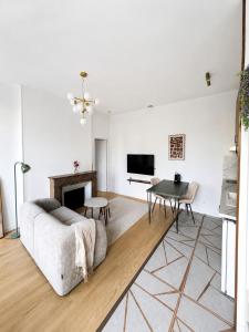 a white living room with a couch and a table at Le cocon de Saumur in Saumur
