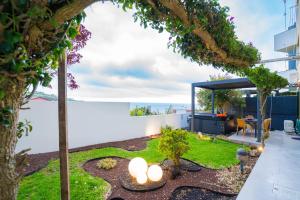 a garden with a view of the ocean at epicenter LAGOA in Lagoa