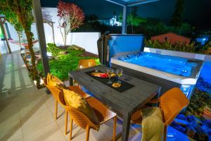 a patio with a table and chairs and a swimming pool at epicenter LAGOA in Lagoa