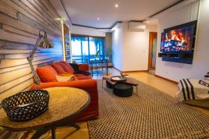 a living room with a couch and a tv at epicenter LAGOA in Lagoa