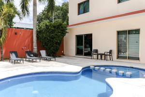 a swimming pool in front of a house at Hotel Ambra in Playa del Carmen