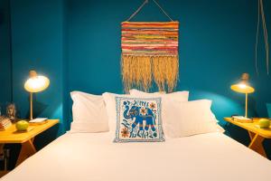 a bedroom with a bed with blue walls and two lamps at epicenter LAGOA in Lagoa +21 photos