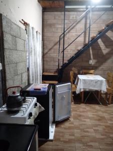 a kitchen with a stove and a table and a staircase at HOSPEDAJE DODERA in Gualeguaychú