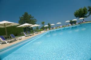 a large swimming pool with chairs and umbrellas at Hotel Emilia in Ancona