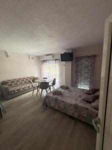 a bedroom with a bed and a table and a couch at Perea white suites in Perea