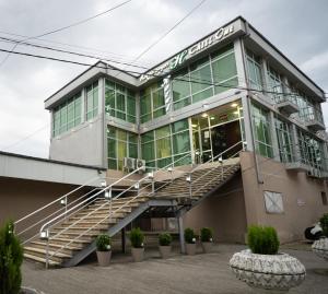 a building with a staircase in front of it at Chill Out Hotel Tskaltubo in Tsqaltubo