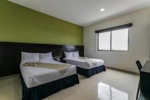 a bedroom with two beds and a window at Hotel Ambra in Playa del Carmen +23 photos