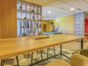 a dining room with a wooden table and chairs at ibis Cholet in Cholet
