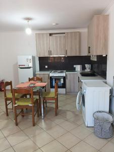 eine Küche mit Tisch und Stühlen, Herd und Kühlschrank in der Unterkunft Amygdalos Room in Kómi