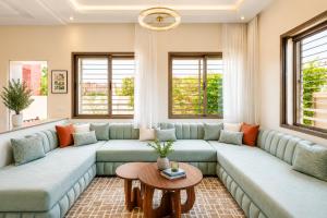 a living room with a large couch and a table at Villa Sara, Piscine et Jardin privée in Marrakesh +65 photos
