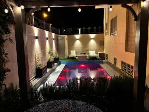 a pool with red lights in a courtyard at night at Villa Sara, Piscine et Jardin privée in Marrakesh