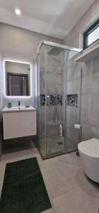 a bathroom with a shower and a toilet and a sink at Palm Suites Algarve in Portimão +22 photos