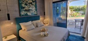 a bedroom with a bed with a hat and slippers on it at Palm Suites Algarve in Portimão