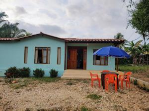 a small house with a table and chairs and an umbrella at Serena Grau in San Antero