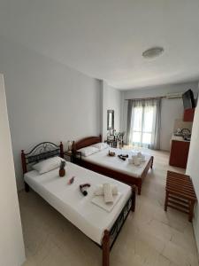 two beds sitting in a room with a kitchen at Santa Magia in Kamari +133 photos