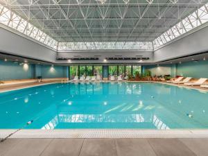 a large indoor swimming pool with a ceiling at Novotel Gdańsk Marina in Gdańsk