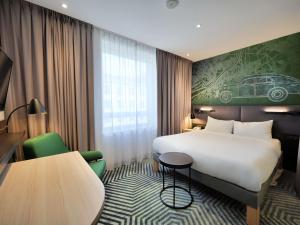 a hotel room with a bed and a table at Mercure Warszawa Grand in Warsaw