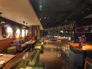 a restaurant with tables and chairs and a bar at Hotel Mercure Poznań Centrum in Poznań