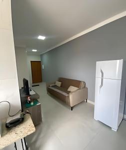 a living room with a couch and a refrigerator at loft espaço inteiro 1 quarto c/ ar condicionado in Indaiatuba