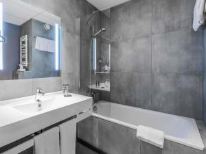 a bathroom with a sink and a bath tub at Novotel Kraków City West in Krakow