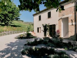 an external view of a white building with a yard at Casale Milleluci - Country House in Senigallia