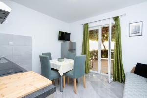 a kitchen and dining room with a table and chairs at Apartment Bogomir in Podgora