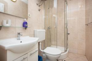 a bathroom with a shower and a toilet and a sink at Apartment Bogomir in Podgora +18 photos