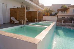 a swimming pool in front of a house at Argassi Beach Hotel - Adults Only in Argassi +31 photos