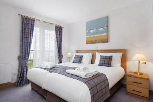 a bedroom with a large bed and a window at No18 The Links Apartment, Brora in Brora