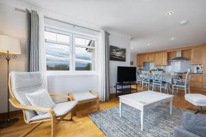 a living room with a couch and a table at No18 The Links Apartment, Brora in Brora