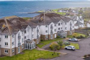 an aerial view of a house with the ocean at No18 The Links Apartment, Brora in Brora