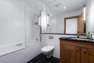 a bathroom with a toilet and a sink and a shower at No18 The Links Apartment, Brora in Brora +4 photos